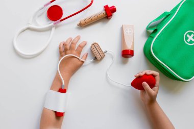 Ahşap enstrümanlar ve yeşil tıbbi çantalı çocuk doktoru oyun seti.