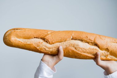 Geniş ekmeği arka planda tutan çocuk.