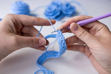 Mavi iplik ve kancayla tığ işi devam ediyor. Yüksek kalite.