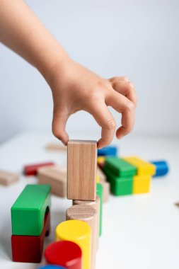Çocuk renkli tahta bloklarla oynuyor. Yüksek kalite.