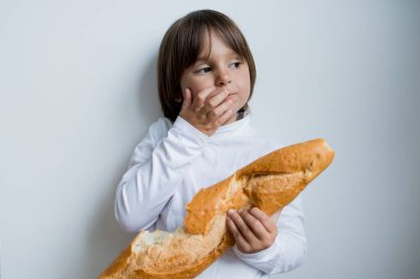 Beyaz arka planda ekmek tutan beyaz bir çocuk..