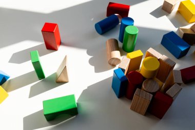 Beyaz arka planda güneş ışığında renkli ahşap geometrik bloklar. Yüksek kalite.