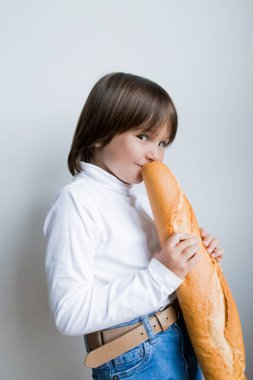 Beyaz balıkçı yaka ve kot pantolon içinde taze baget yiyen beyaz bir kız..