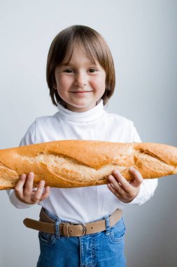Beyaz çocuk elinde neşeli bir ifadeyle baget tutuyor..