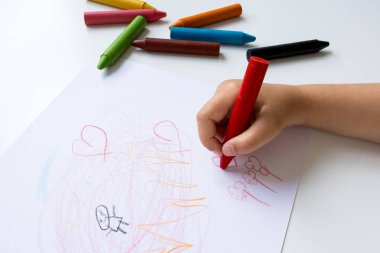 Beyaz kağıda pastel boyayla çocuk eli çizimi. Yaratıcı sanat etkinliği.