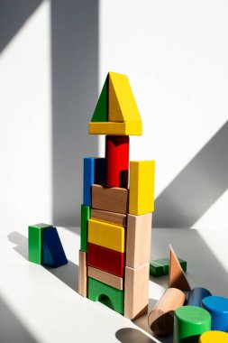 Sanatsal gölgeli güneşli odada renkli tahta bloklar kulesi. Yüksek kalite.