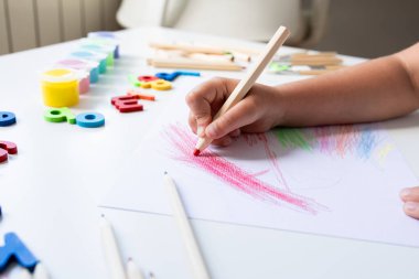 Masada kalem ve alfabe öğrenme araçlarıyla çocuk boyama. Yüksek kalite.