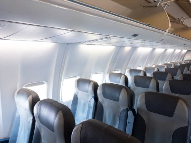 Boş uçak kabini, gri koltuklar ve tepedeki kutular. Yüksek kalite.