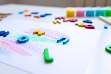 Çocuk resim masasında renkli alfabe harfleri ve pastel çizimler. Yüksek kalite.