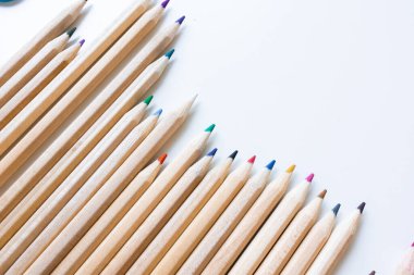 Beyaz arka plana dizilmiş renkli tahta kalemler. Yüksek kalite.