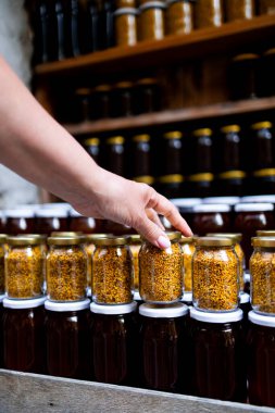 Çiftçi pazarı vitrininde dişi arı poleni kavanozu. Yüksek kalite.