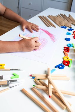 Beyaz masa üzerinde kurşun kalemlerle ve harflerle çocuk boyası. Yüksek kalite.