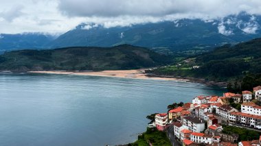 1 Haziran 2025. Lastres, İspanya. Huzur koyuna ve yemyeşil tepelere bakan kırmızı çatıları olan kıyı köyü. Yüksek kalite.