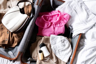 Günlük kıyafetlerle, aksesuarlarla ve tuvalet eşyalarıyla dolu bir bavul. Yüksek kalite.