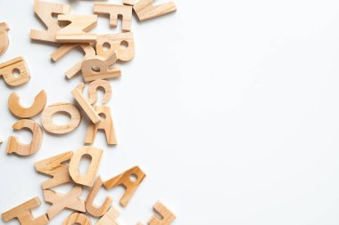 Eğitim ve zanaat kullanımı için beyaz arka plana saçılmış tahta alfabe harfleri. Yüksek kalite.