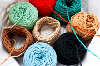 Farklı dokularda renkli iplik topları ve sepetin içinde sıralanmış parlak renkler. Yüksek kalite.