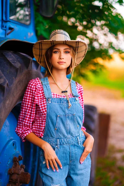 Beautiful Blonde Cowgirl Straw Hat Denim Overall Standing Blue Tractor — Stock Photo, Image