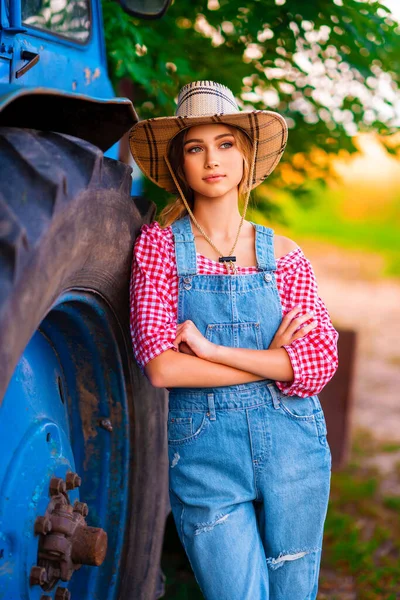 Beautiful Blonde Cowgirl Straw Hat Denim Overall Standing Blue Tractor — Stock Photo, Image