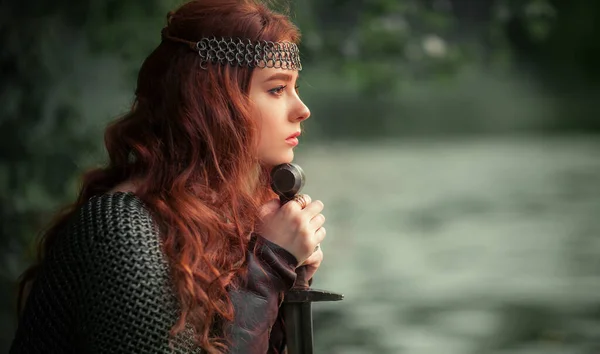 金属中世の鎧の美しい赤い髪の女の子は 剣のポーズで立っている 戦士に関するおとぎ話 暖かい作品 — ストック写真