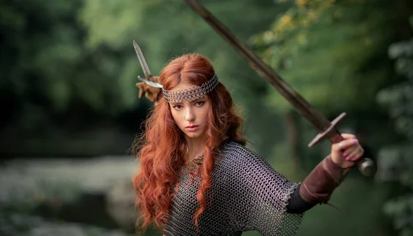 金属中世の鎧の美しい赤い髪の女の子は 剣のポーズで立っている 戦士に関するおとぎ話 暖かい作品 — ストック写真