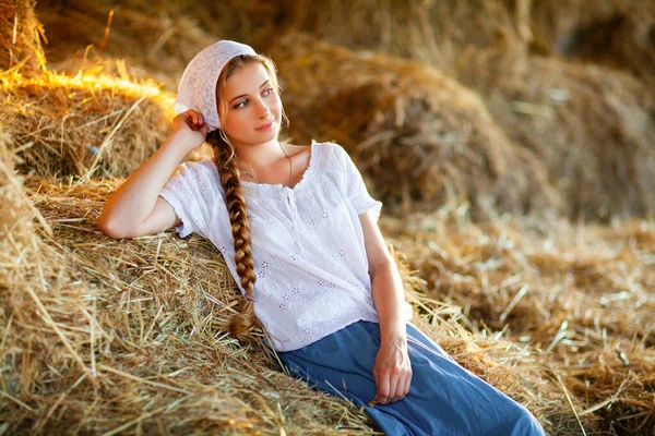 Όμορφη Ξανθιά Κοπέλα Πλεγμένα Μαλλιά Λευκά Αγροτικά Ρούχα Κάθεται Ένα — Φωτογραφία Αρχείου