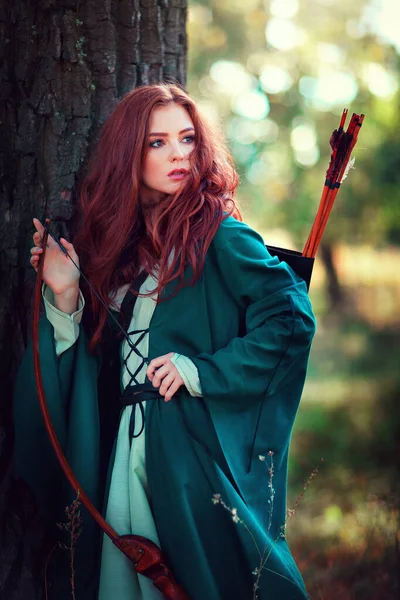 輝く太陽の下で緑の中世のドレスで美しい赤い髪の少女の肖像画 勇敢な心の女性についてのおとぎ話 カメラを見て驚くべきモデル — ストック写真