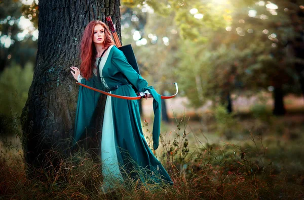 輝く太陽の下で緑の中世のドレスで美しい赤い髪の少女の肖像画 勇敢な心の女性についてのおとぎ話 カメラを見て驚くべきモデル — ストック写真