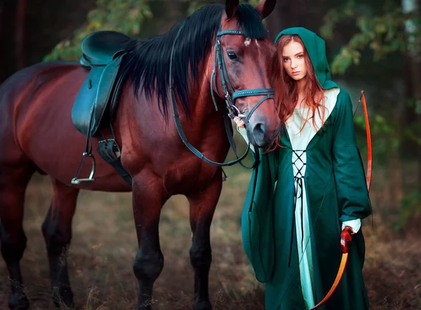 馬の上に座って遠くを見て緑の中世のドレスで美しい赤髪の女の子 勇敢な心の女性についてのおとぎ話 暖かい作品 — ストック写真