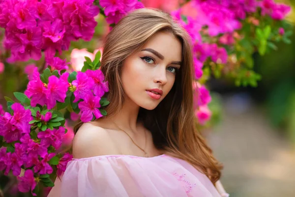 美丽的女孩穿着粉红的古装 戴着草帽 站在五彩缤纷的花朵旁边 浪漫女人的艺术作品 漂亮温柔的模特 摆出姿势 看着镜头 — 图库照片
