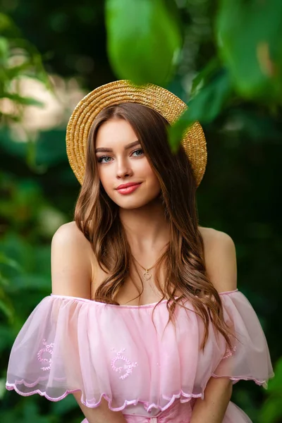 Yeşil Arka Planda Çiçekli Pembe Bir Elbise Hasır Şapkayla Duran — Stok fotoğraf