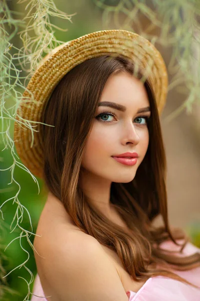 Yeşil Arka Planda Çiçekli Pembe Bir Elbise Hasır Şapkayla Duran — Stok fotoğraf