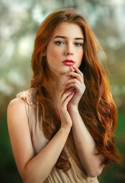 春開花庭に立って白いレースのドレスで美しいロマンチックな赤い髪の女の子 若いモデルを夢見てカメラを見て — ストック写真