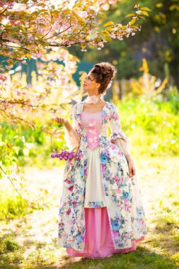 Çiçekli manolya bahçesinde dikilen mükemmel saç stiline sahip güzel romantik kız. Peri masalı gibi giyinmiş rüya kraliçesi. Peri masalı gibi..