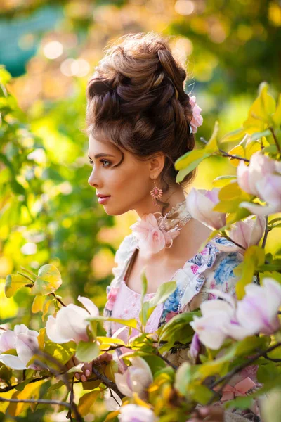 美丽的浪漫姑娘 完美的发型 屹立在盛开的木兰花花园里 穿着童话般美丽的古装的梦幻女王 童话艺术作品 — 图库照片
