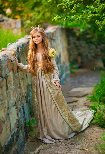 금발의 아름다운 금발의 공주가 시대의 황금색 드레스와 왕관을 아름다운 근처에 — 스톡 사진