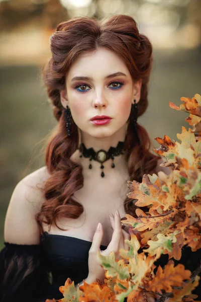 美丽的时尚哥特式女孩站在秋天树旁边的画像 幻想的艺术品 漂亮的红头发模特 穿着黑色衣服 头戴黑色帽子 看着相机和照片 关于年轻公主的童话 — 图库照片