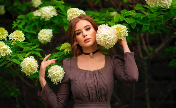 Kahverengi Uzun Ortaçağ Elbisesi Beyaz Çiçeklerin Yanında Duran Eski Moda — Stok fotoğraf