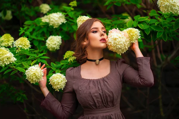 Kahverengi Uzun Ortaçağ Elbisesi Beyaz Çiçeklerin Yanında Duran Eski Moda — Stok fotoğraf