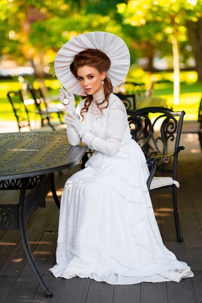Рыжеволосая Девушка Белом Длинном Винтажном Платье Шляпе Сидящая Возле Винтажного — стоковое фото