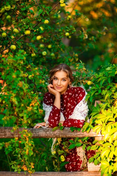 Kıvırcık Uzun Saçlı Kırmızı Kadife Elbiseli Elma Bahçesinde Poz Veren — Stok fotoğraf