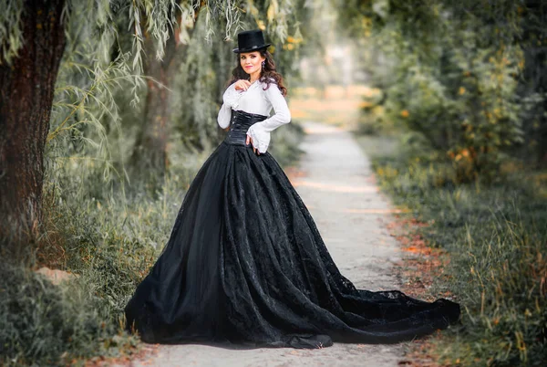 壮大なファッションゴシックガールの肖像 ファンタジーアート作品黒の白いドレスと帽子のポーズで素晴らしいブルネットのモデル — ストック写真