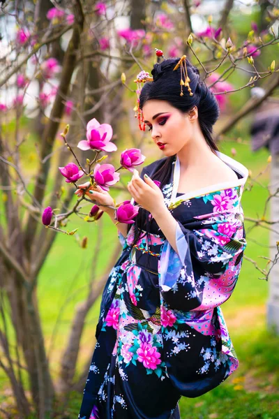美丽的亚洲黑发女孩 头发缠住 和服摆设在花圃中 日本年轻模特的春季肖像 — 图库照片