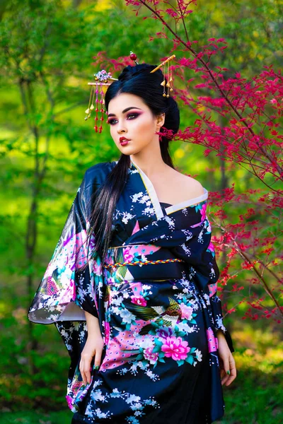 美丽的亚洲黑发女孩 头发缠住 和服摆设在花圃中 日本年轻模特的春季肖像 — 图库照片
