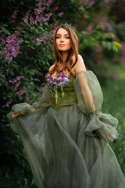 Великолепная Королева Короне Красивом Зеленом Длинном Платье Цветами Позирующими Саду — стоковое фото