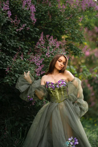 Великолепная Королева Короне Красивом Зеленом Длинном Платье Цветами Позирующими Саду — стоковое фото
