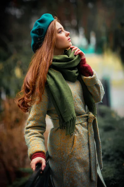 一个戴着绿色围巾 头戴蓝色帽子 背景五彩斑斓的红头发美女的画像 爱情女子的艺术作品 美丽柔情的典范 远眺远方 — 图库照片