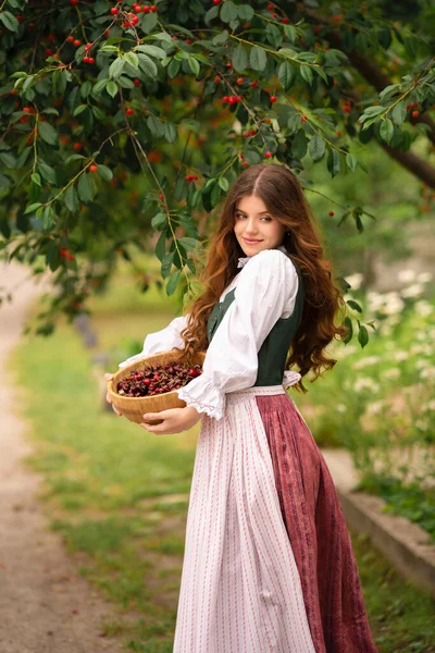 Ortaçağ Elbiseli Güzel Kızıl Saçlı Kız Kiraz Ağacının Yanında Duruyor — Stok fotoğraf