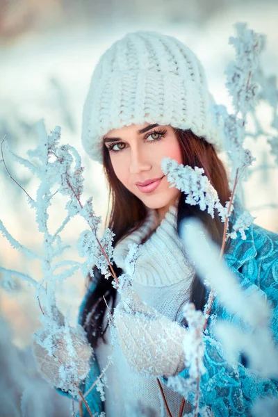 冬霜森林里穿着白色针织帽子的漂亮女孩的画像 蓝色背景的漂亮年轻模特儿笑着 — 图库照片