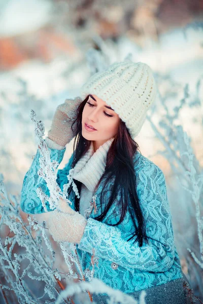 冬霜森林里穿着白色针织帽子的漂亮女孩的画像 蓝色背景的漂亮年轻模特儿笑着 — 图库照片