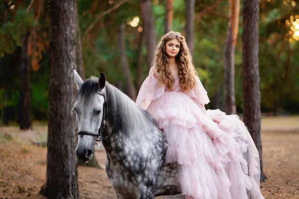 松林で灰色の馬とポーズする長い魅力的なドレスの長い髪の美しい少女 暖かいおとぎ話のアートワーク — ストック写真